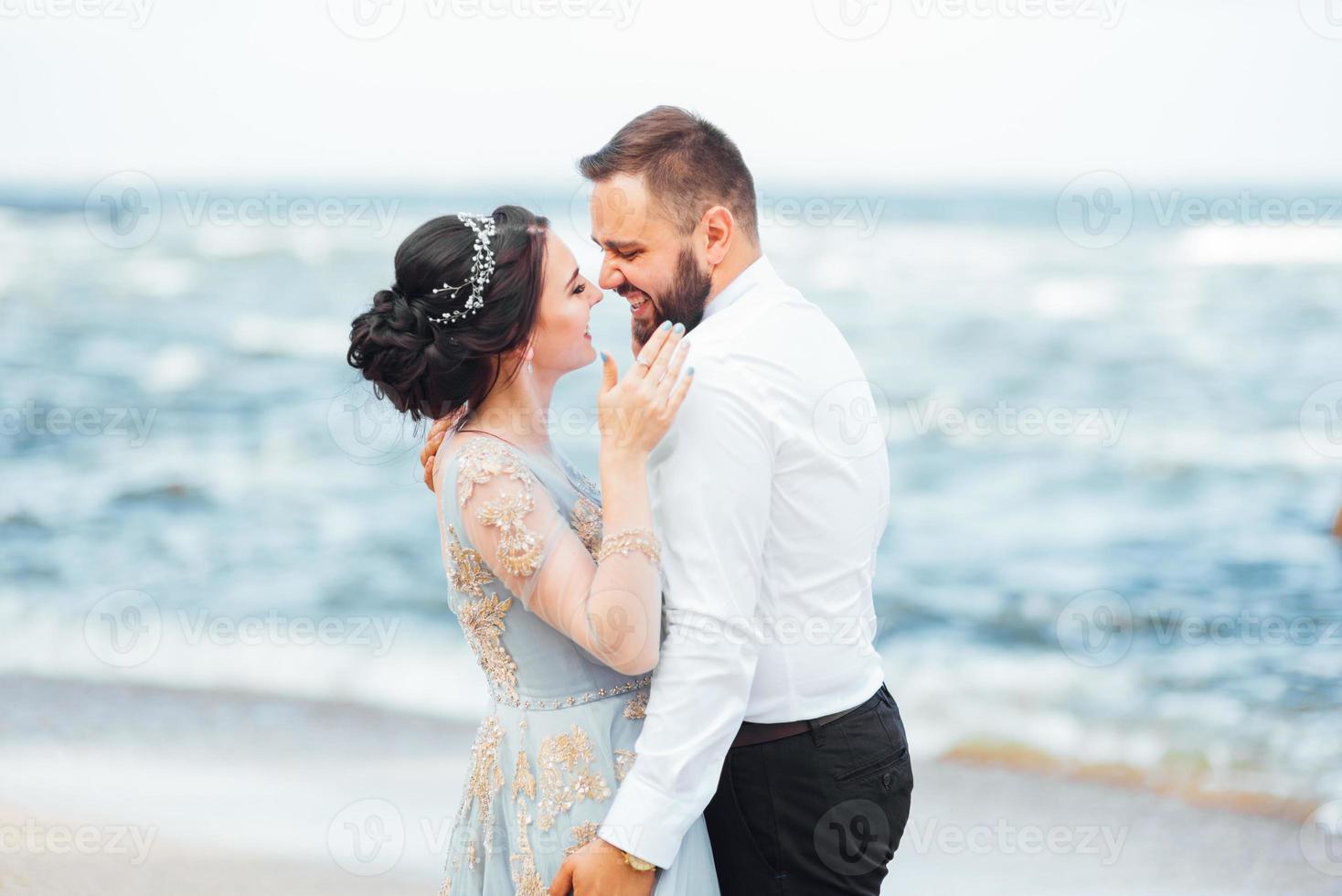 das gleiche Paar mit einer Braut in einem blauen Kleid zu Fuß foto