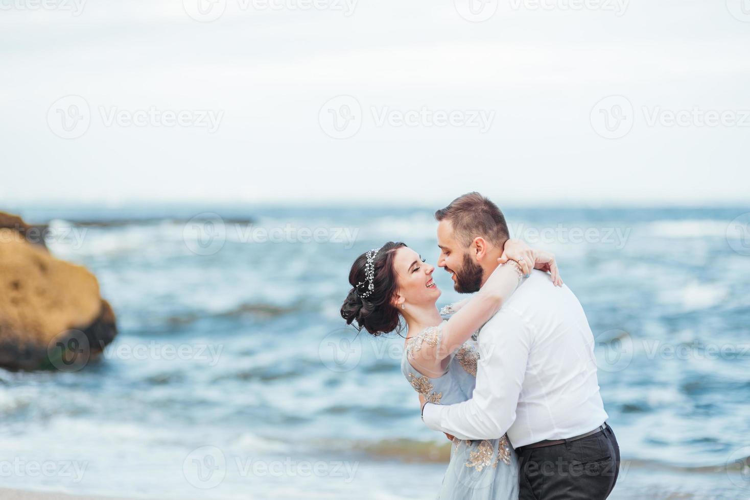 das gleiche Paar mit einer Braut in einem blauen Kleid zu Fuß foto