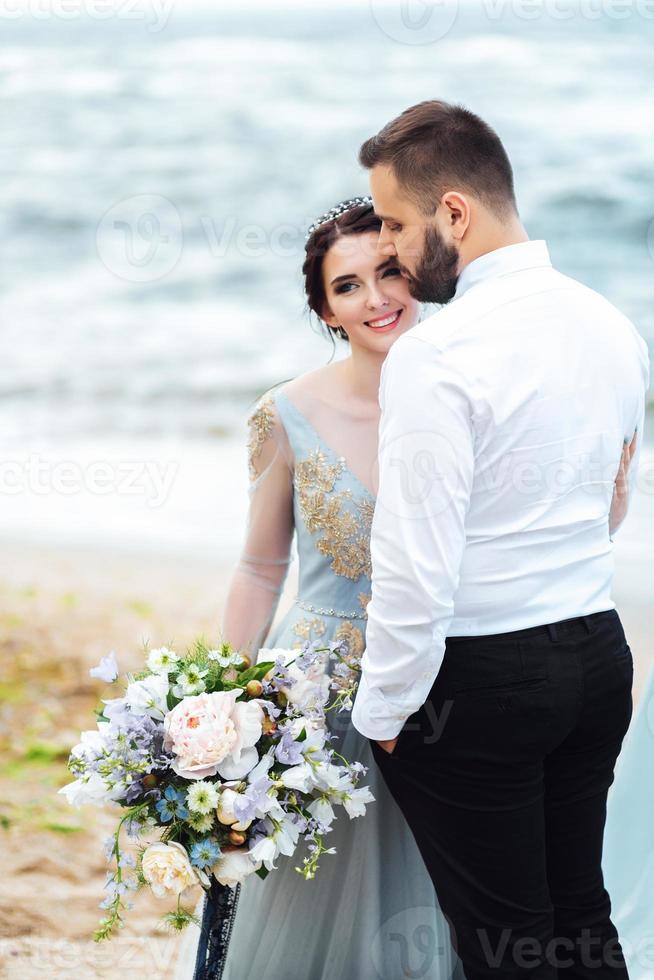 das gleiche Paar mit einer Braut in einem blauen Kleid zu Fuß foto