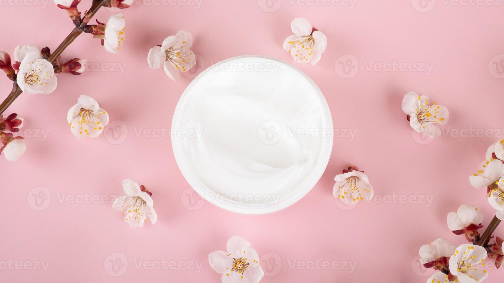 Creme und Blumen auf rosa Hintergrund, Schönheits-Hautpflegekosmetik foto