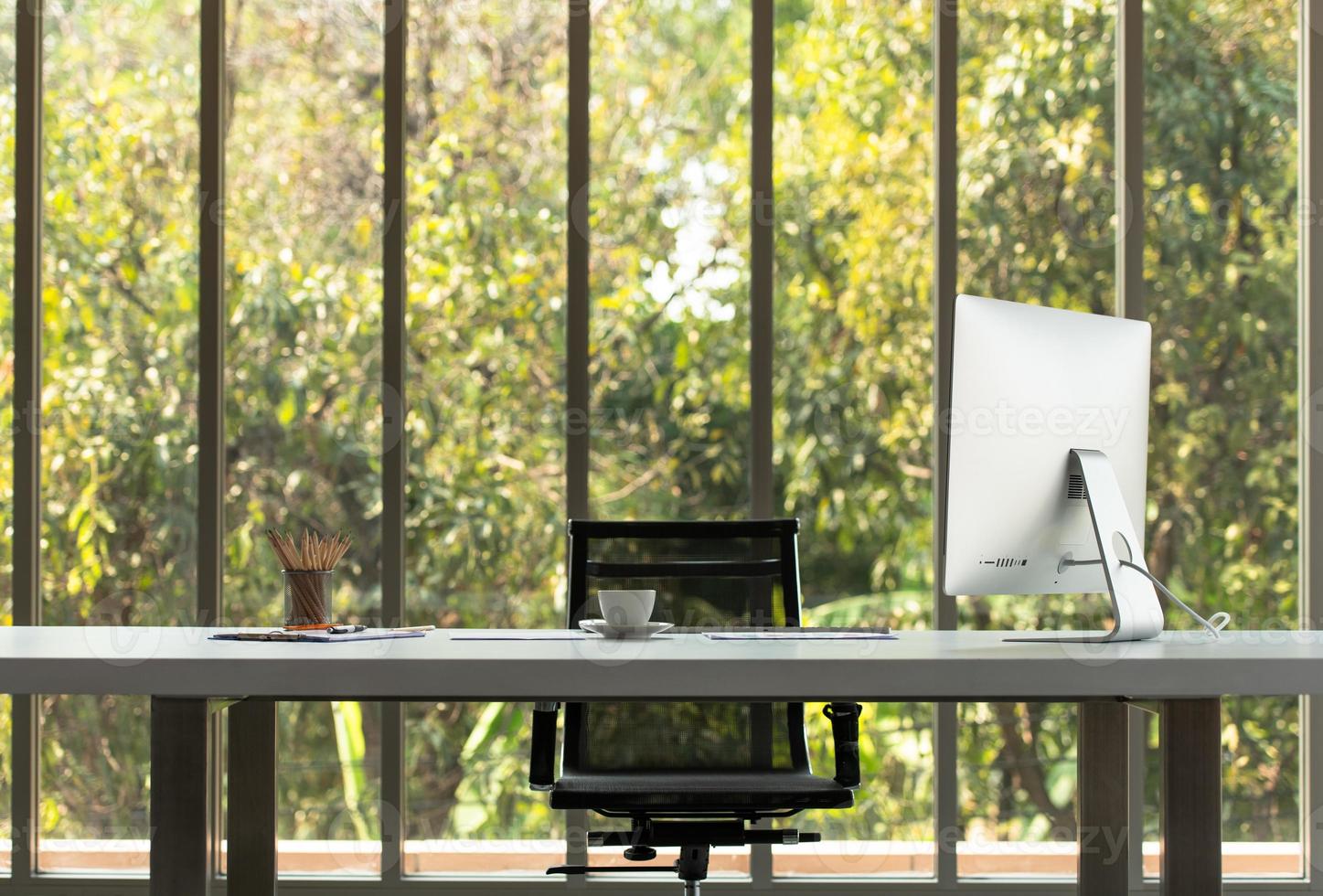 ein großer Tisch mit einem Computer von CEO und Naturhintergrund foto