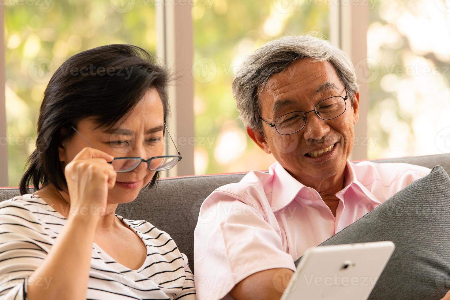 Senior asiatischer Mann und Frau entspannen im Urlaub im natürlichen Wohnzimmerhintergrund mit moderner Technologie foto