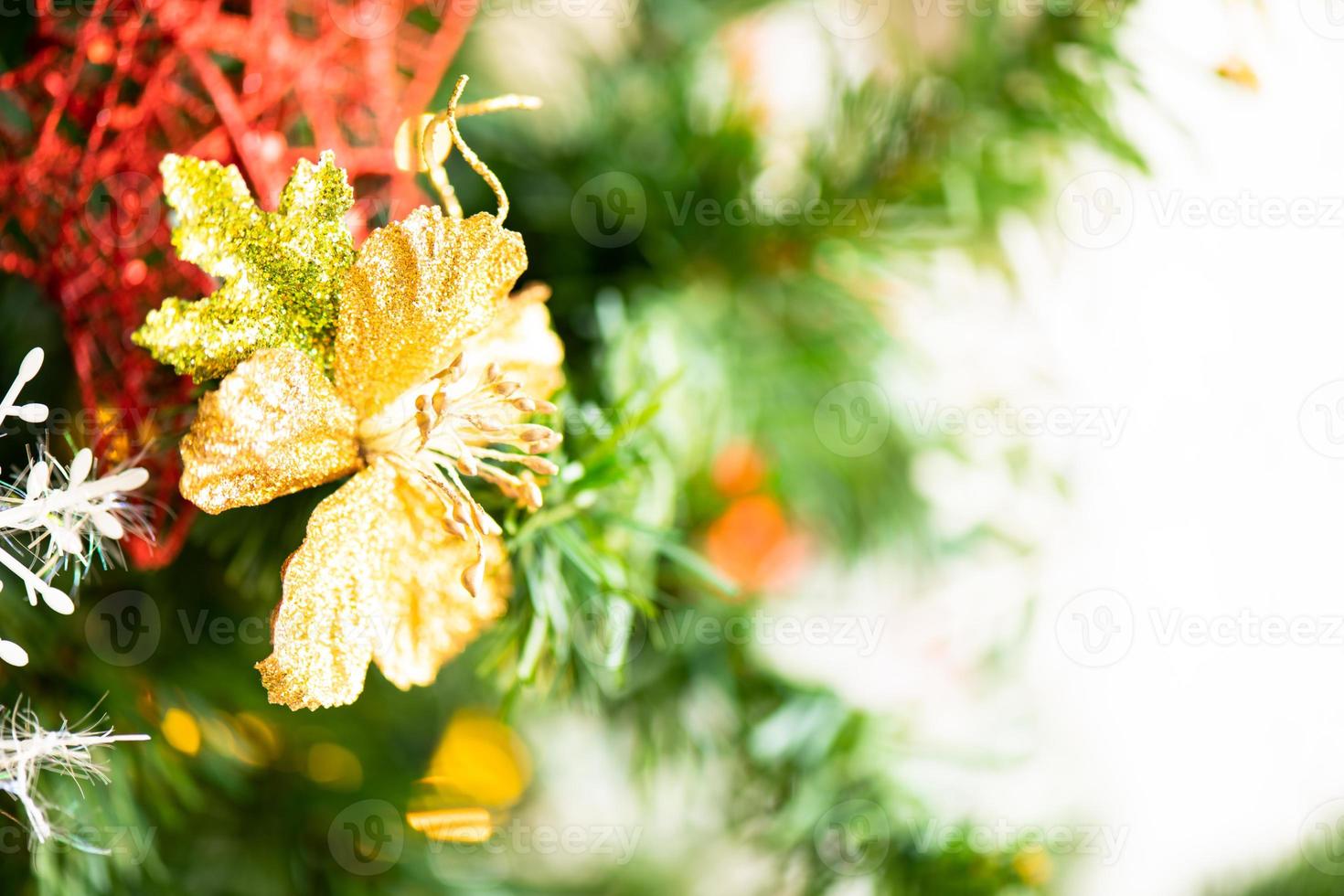 Weihnachtsbaum im Wohnzimmer geschmückt, um sich auf das neue Jahr vorzubereiten. Dekorieren Sie das Wohnzimmer und den Weihnachtsbaum mit einer Schachtel roter Kugeln, goldener Kugeln, goldener Glocken, Schneesterne und Socken. foto