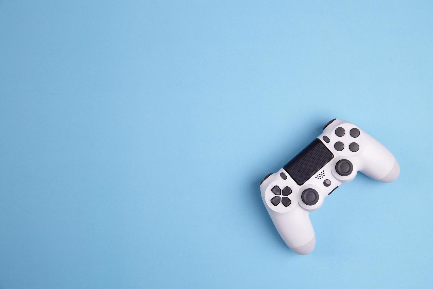 Joystick-Gaming-Controller isoliert auf blauem Hintergrund, entwickelte Videospielkonsole interaktive Unterhaltung foto