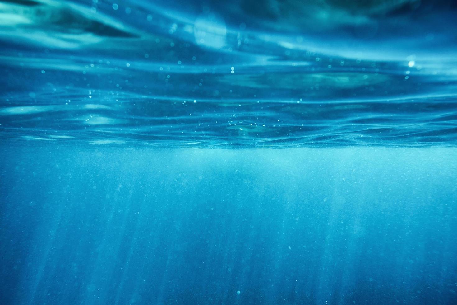 Oberflächenwelligkeit unter Wasser blauen Ozean mit Sonnenstrahl im tropischen Meer foto