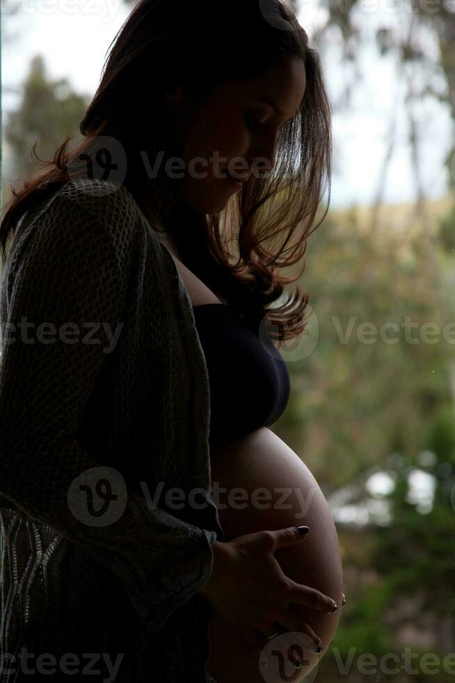 Hintergrundbeleuchtung von ein jung Frau erwarten ihr Baby - - 38 Wochen foto