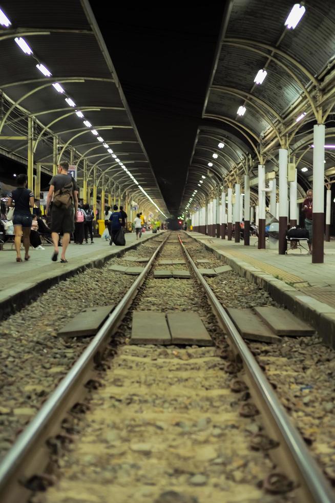 Überfüllte Menschen, die am Bahnsteig des Bahnhofs auf den Zug warten foto