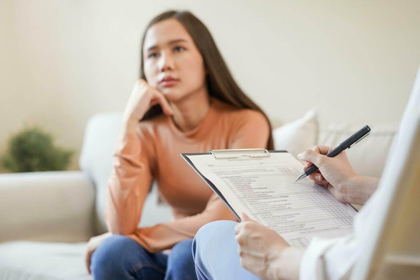 Psychologie, Depression. traurig, Leiden asiatisch jung Frau Beratung mit Psychologe, Psychiater während geduldig Beratung mental mit Arzt Frau nehmen Anmerkungen beim Klinik. ermutigend, Therapie. foto