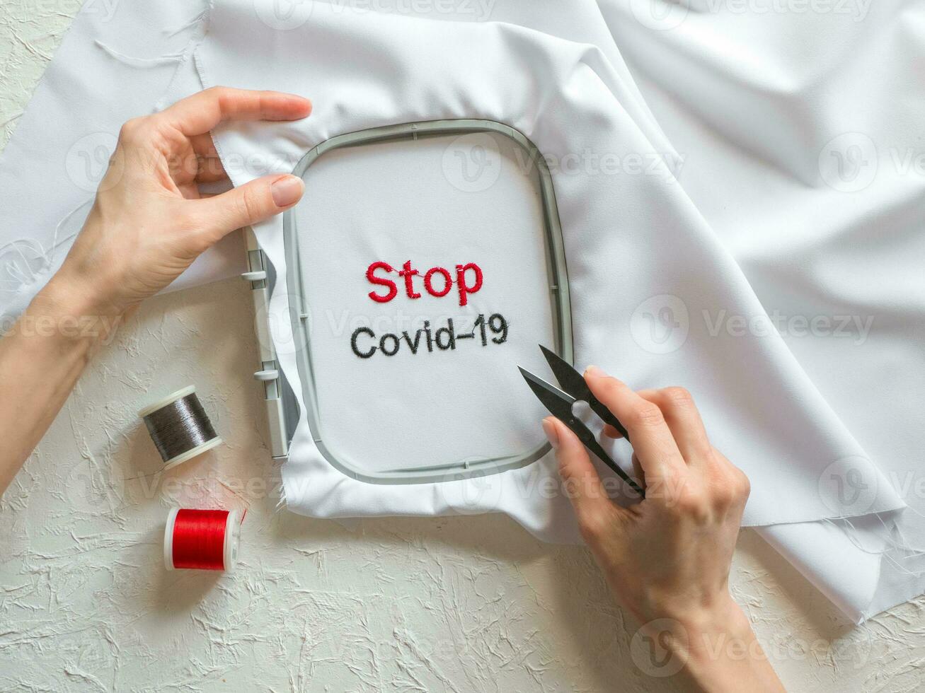 covid-19 Anti Coronavirus kreativ Konzept. das Wörter sind gestickt auf ein Weiß Stoff foto