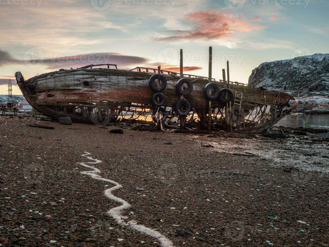 ein alt rostig Angeln Boot verlassen durch ein Sturm auf das Ufer. Friedhof von Schiffe, alt Angeln Dorf auf das Ufer von das Barents Meer, das Kola Halbinsel, teriberka foto