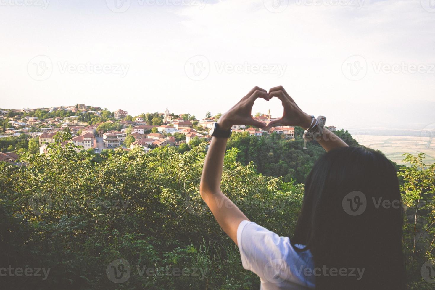 Herz machen mit Händen mit einer Stadt in Sicht foto