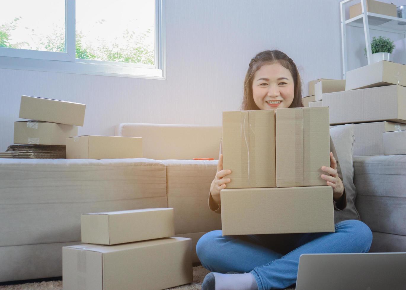 schöne asiatische Frau, die zu Hause sitzt und online arbeitet foto