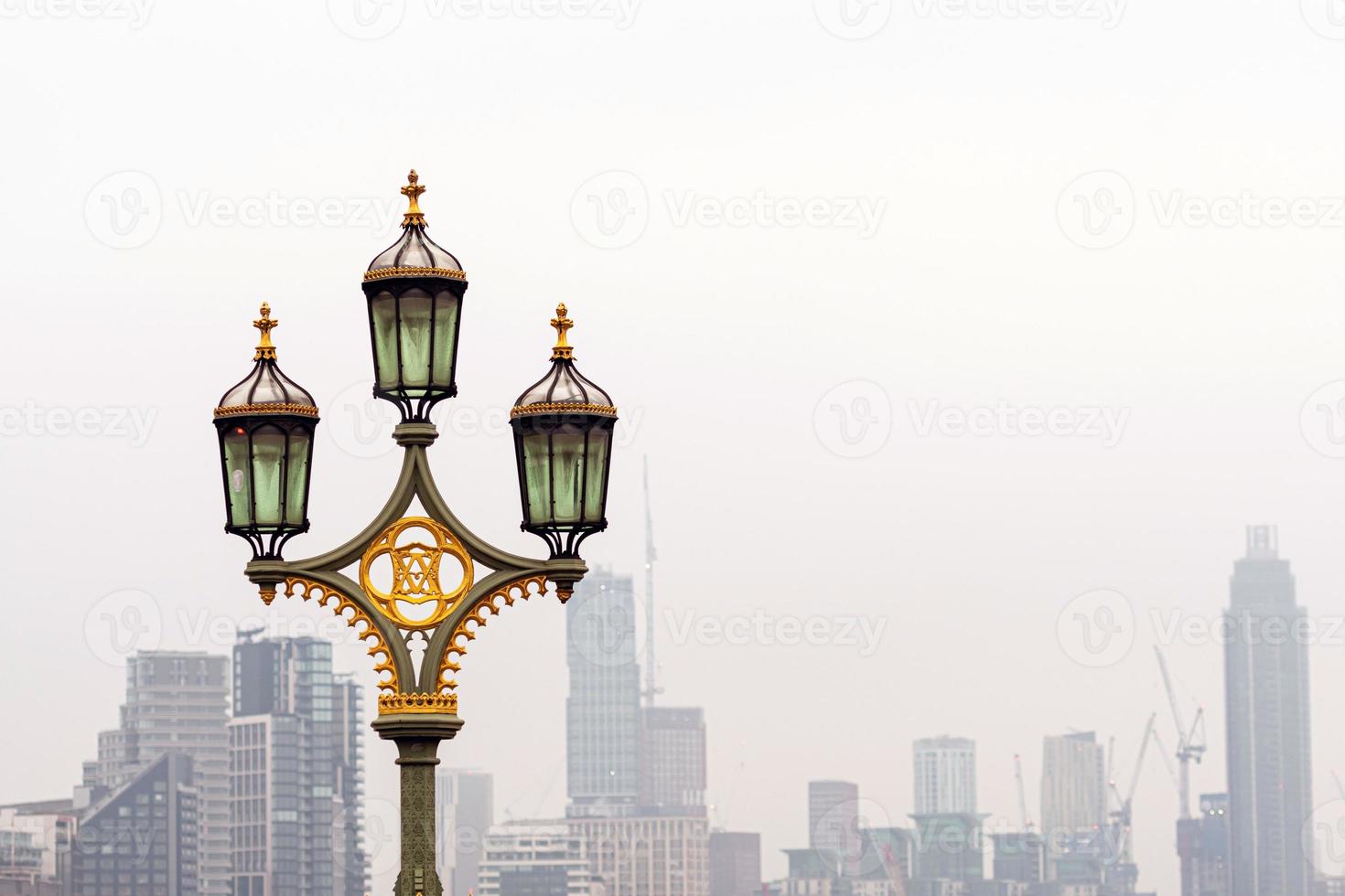 Straßenlaternen auf Westminster Bridge, verschmutzte Wolkenkratzer auf Hintergrund, London, Großbritannien foto