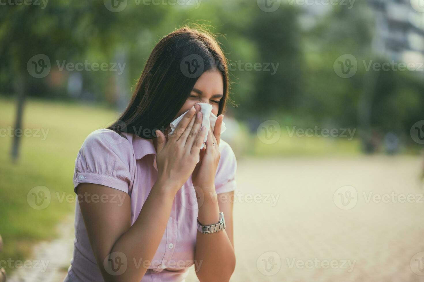 Frau weht ihr Nase auf das Park foto