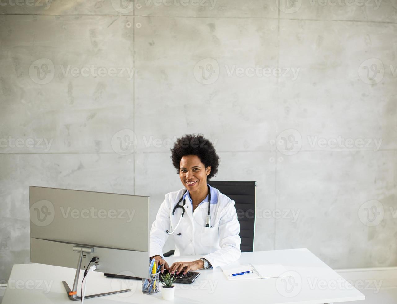 Arzt an einem Schreibtisch mit Kopierraum foto
