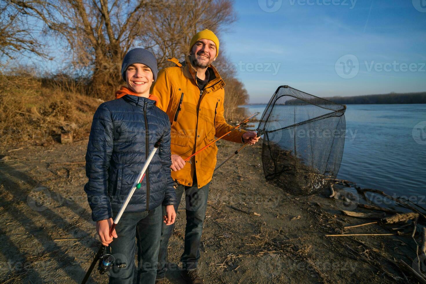 Vater und Sohn sind Angeln auf sonnig Winter Tag foto