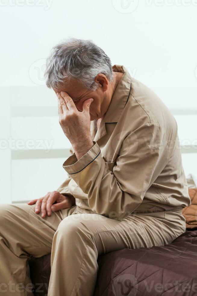 ein Senior schläfrig Mann im seine Schlafzimmer foto