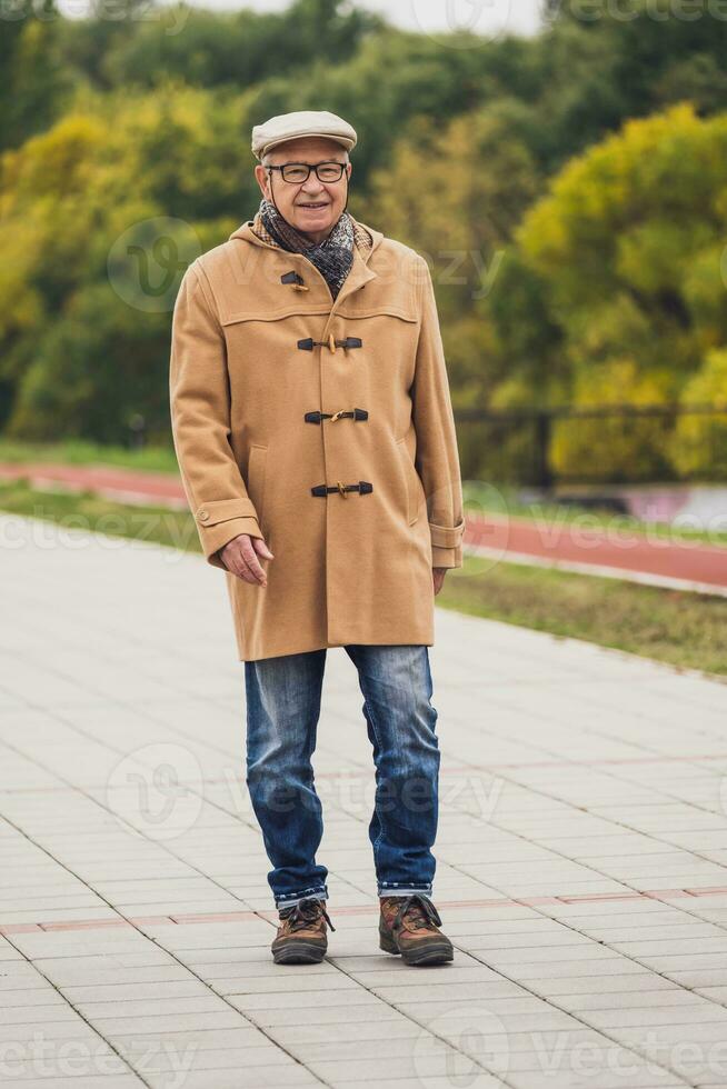 draussen Porträt von ein Senior Mann Gehen im das Park foto