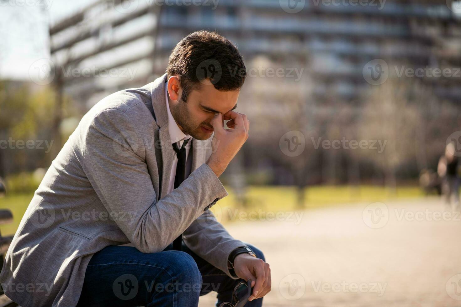 ein Geschäftsmann Sitzung auf ein Park Bank foto