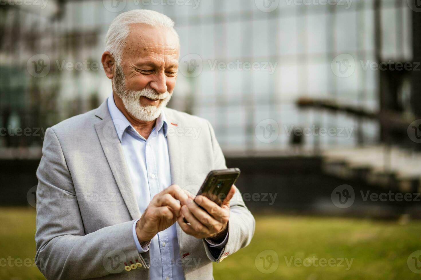 ein Senior Geschäftsmann Überprüfung seine Telefon foto