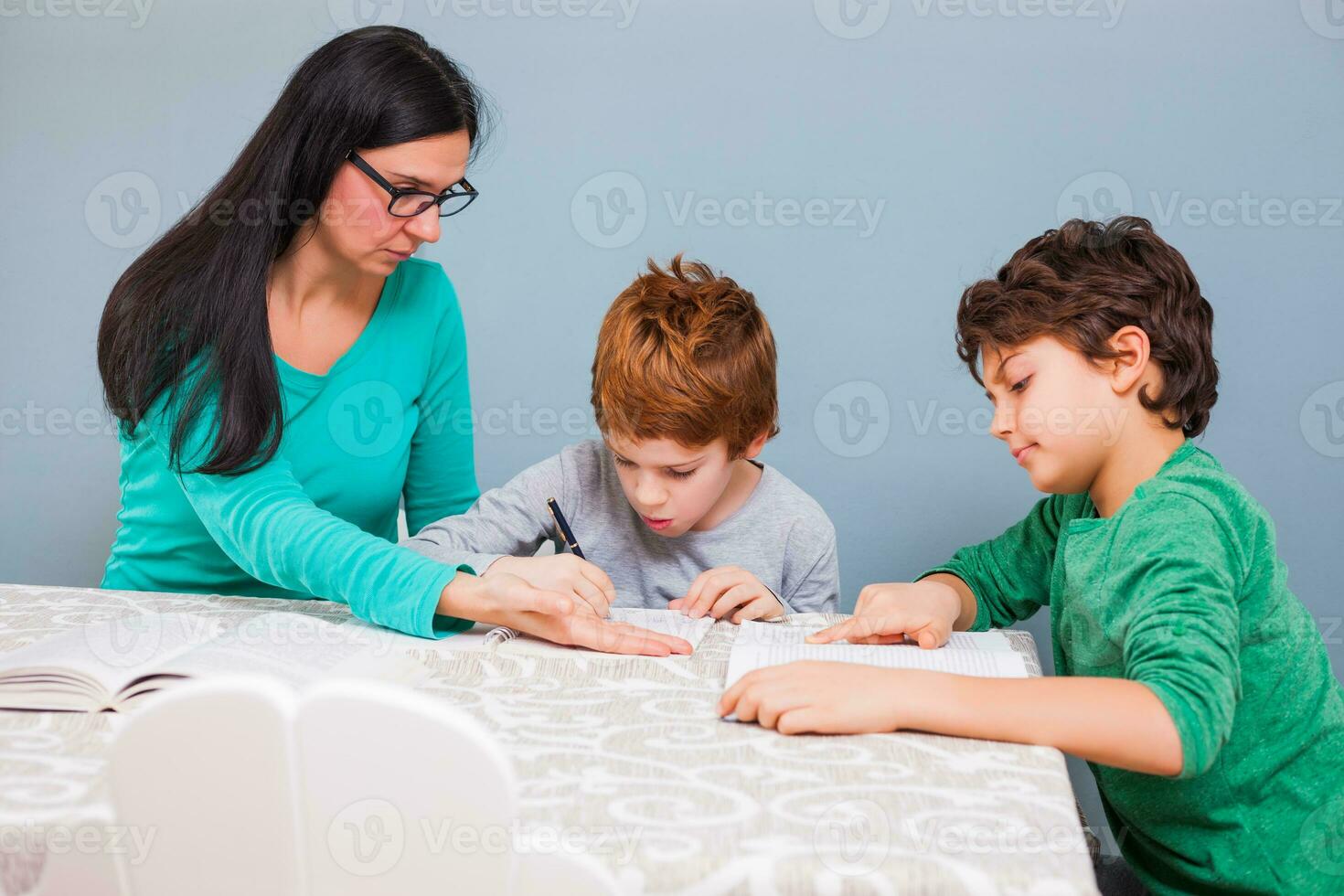 ein Mutter Portion ihr Kinder mit das Hausaufgaben foto