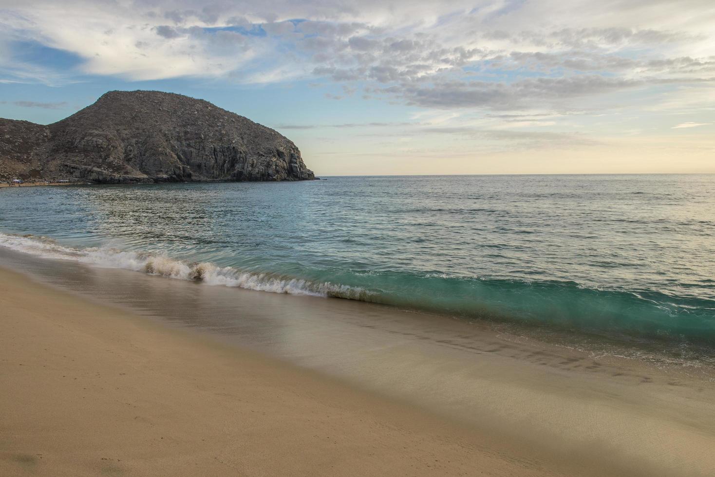 punta lobos todos santos baja kalifornien sur mexiko sonnenuntergang am strand mit bergen im hintergrund und wellen, die am strand brechen foto