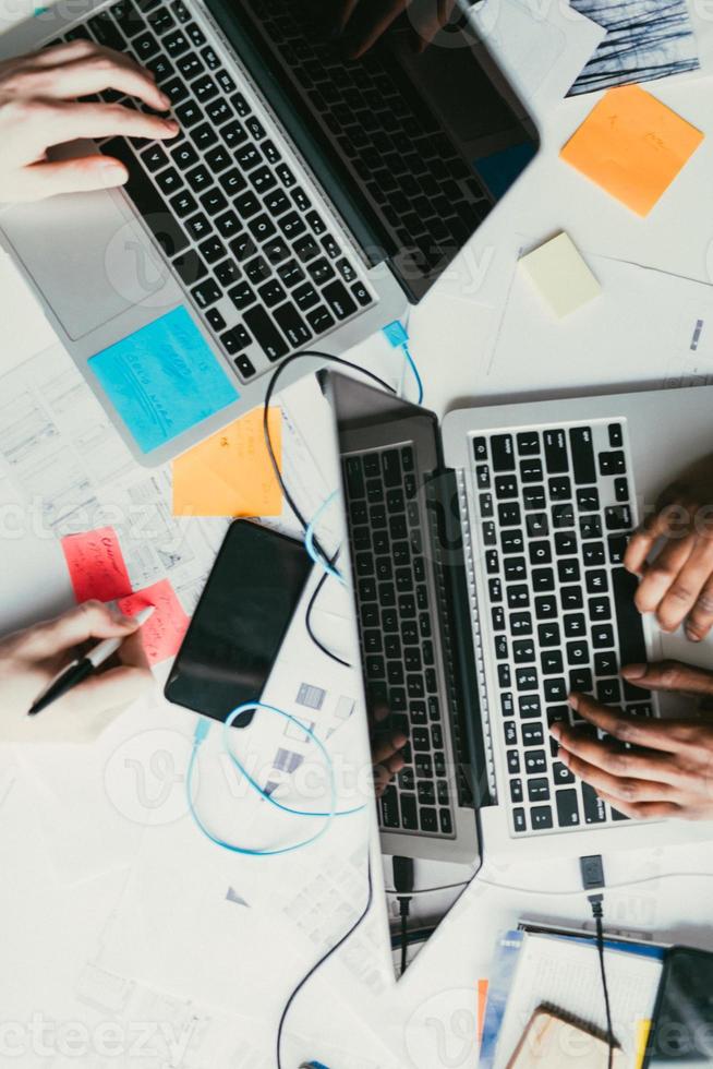 Overhead-Hände, die an Laptops arbeiten foto