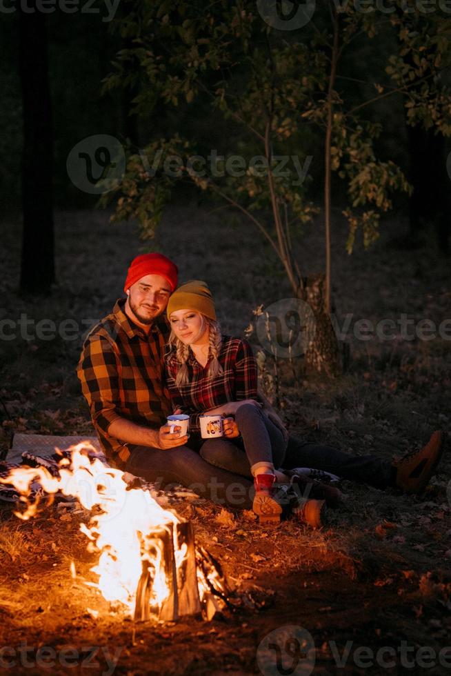 Ein junges Paar, ein Mann und ein Mädchen in bunten Strickmützen, hielten auf einem Campingplatz an foto