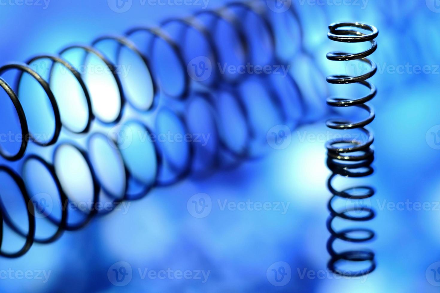 Nahaufnahmebild von Metallfedern auf blauem Hintergrund foto