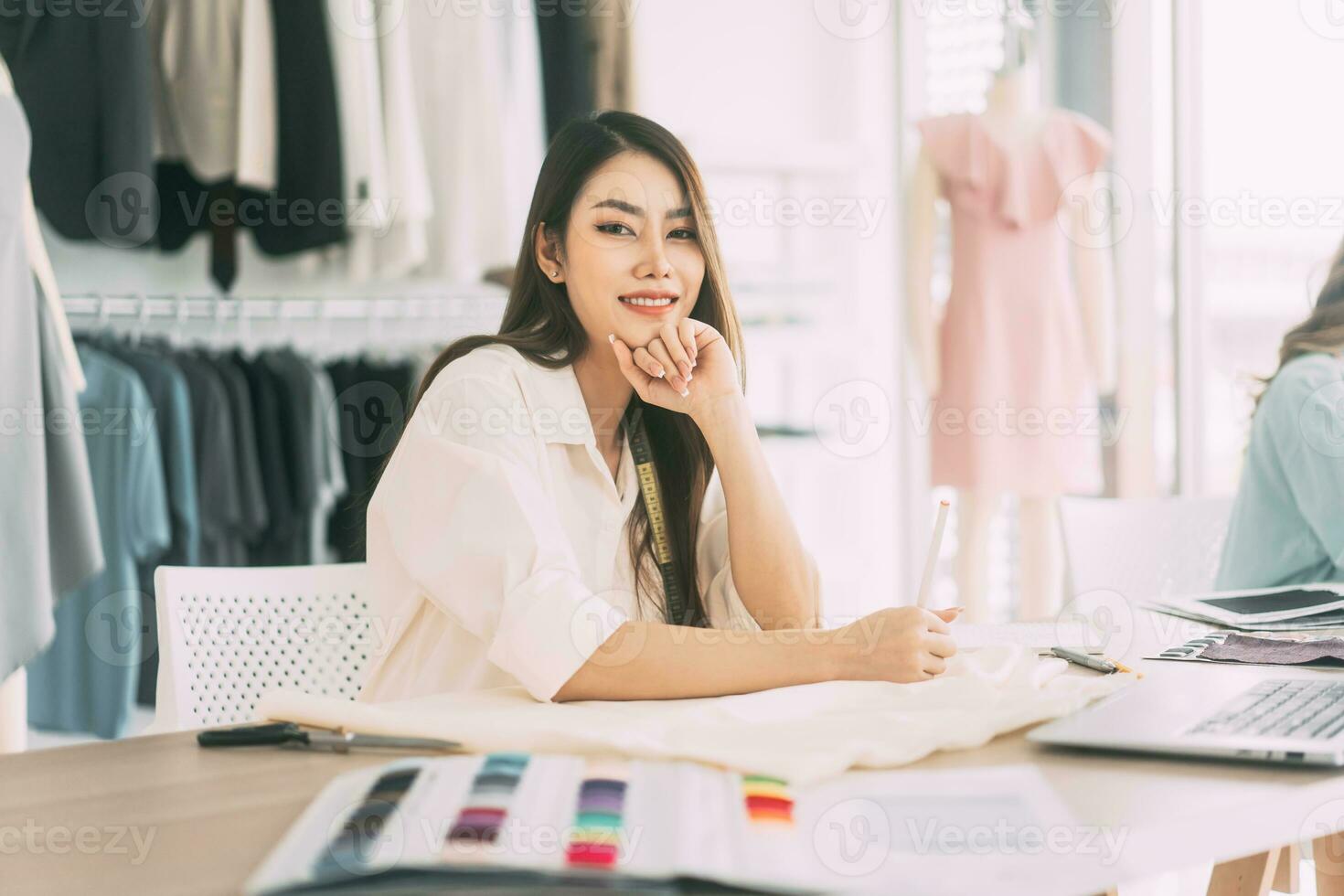 asiatisch Frau Designer beschäftigt Herstellung Kleider Arbeit oder Studie im Mode Design Studio foto