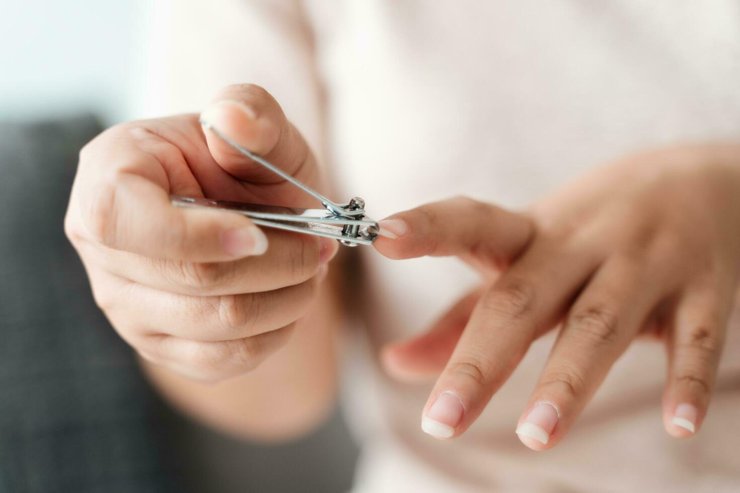 Frau Schneiden Fingernägel mit Nagel Haarschneidemaschine, Gesundheitspflege, Schönheit Konzept. foto