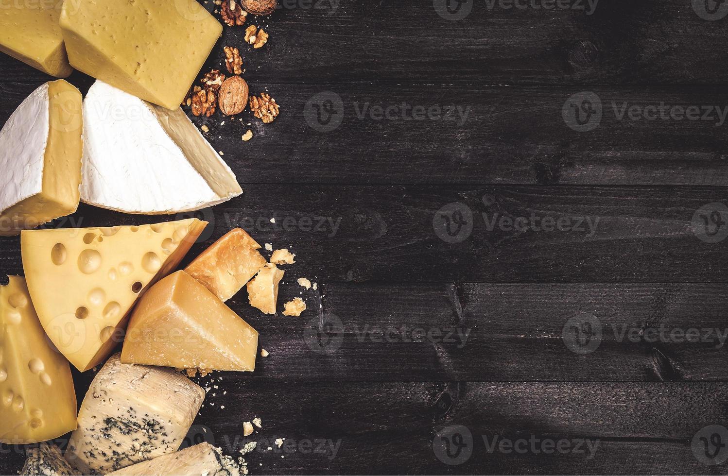 verschiedene Arten von Käse auf schwarzem Holzhintergrund mit Kopierraum foto