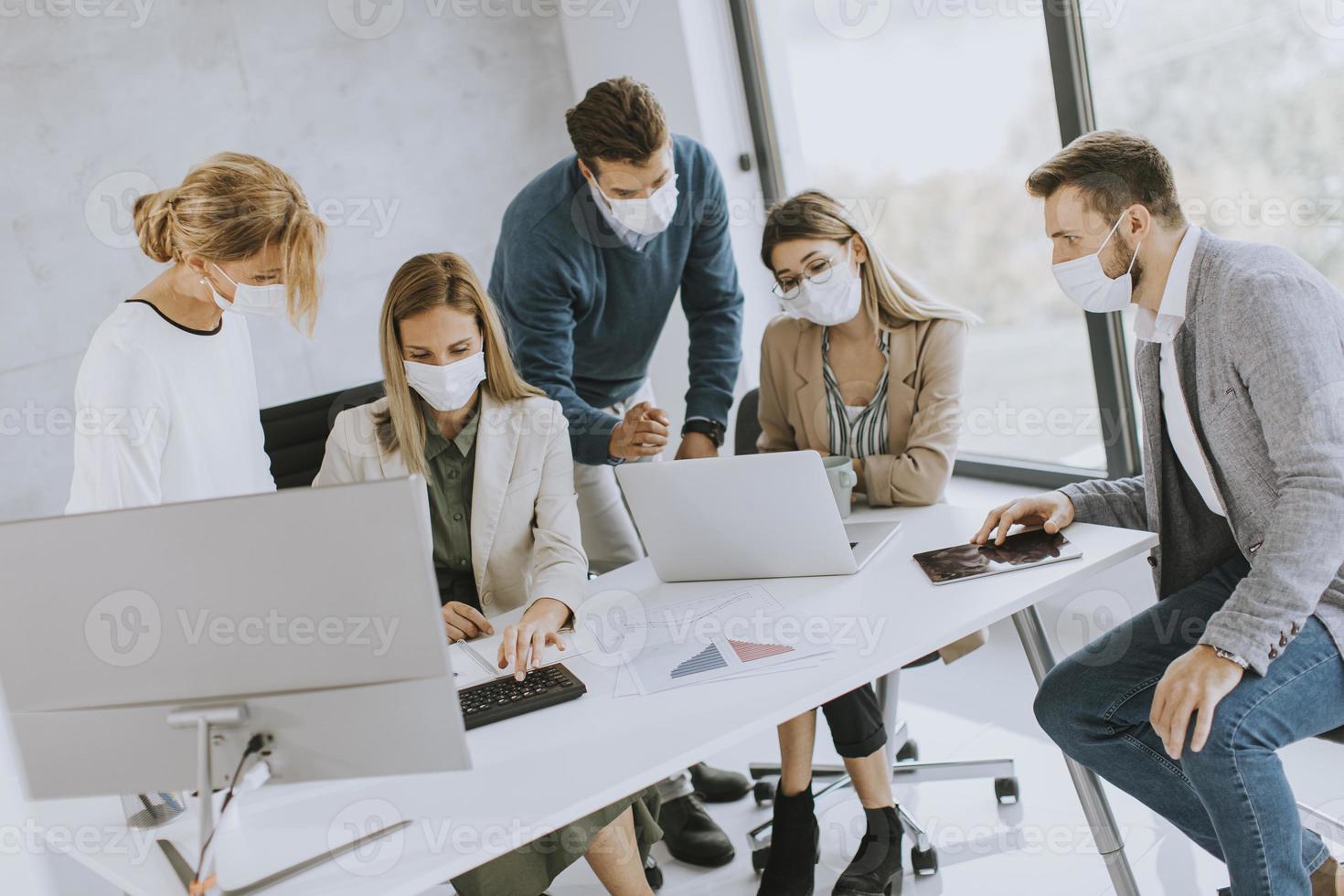 Gruppe in einer Besprechung mit Masken auf foto