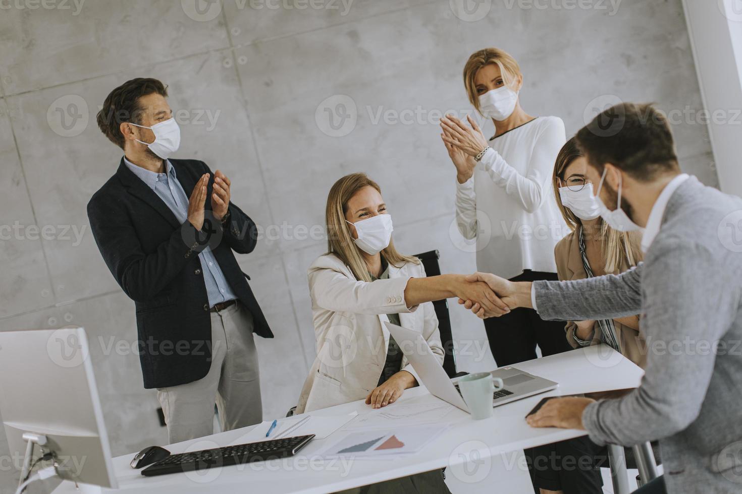 Geschäftsvereinbarung mit Menschen, die Masken tragen foto