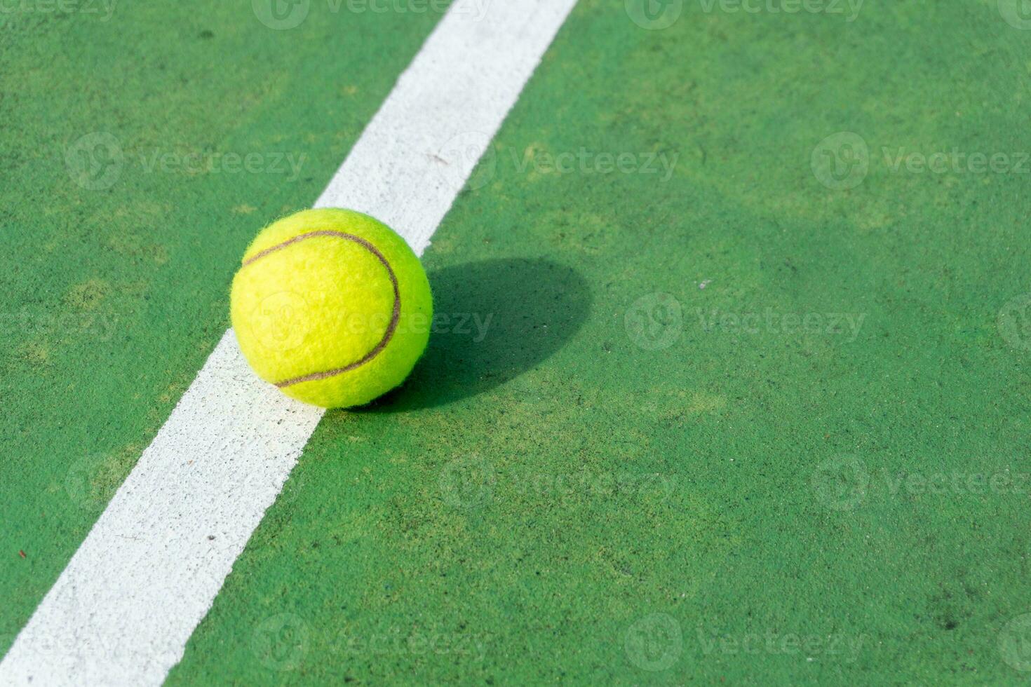 Gelb Tennis Ball auf Grün Gericht und Weiß Linien. oben Winkel Aussicht von Tennis Ball auf Gericht. foto