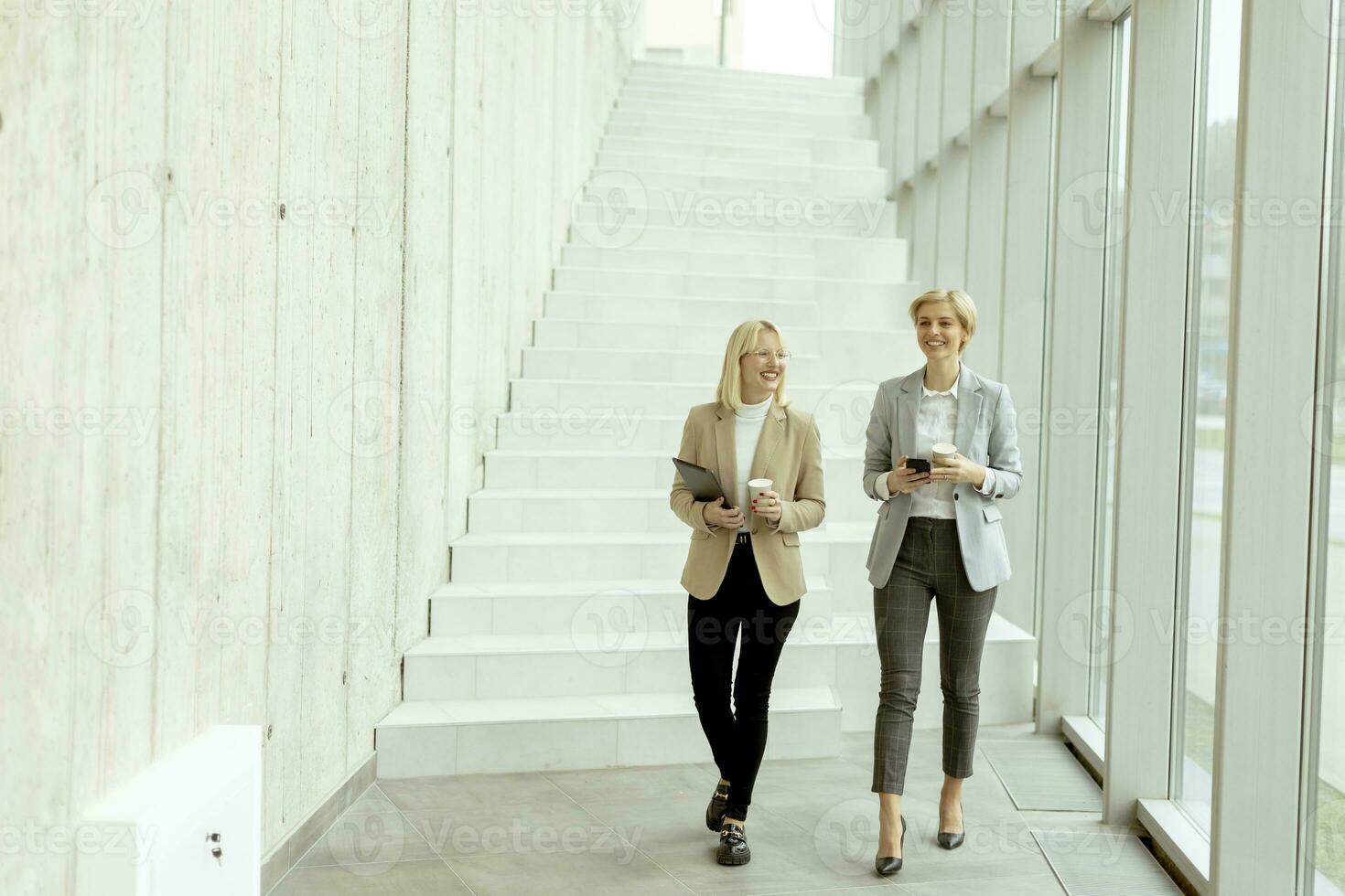 geschäftsfrauen, die in den bürokorridor gehen foto