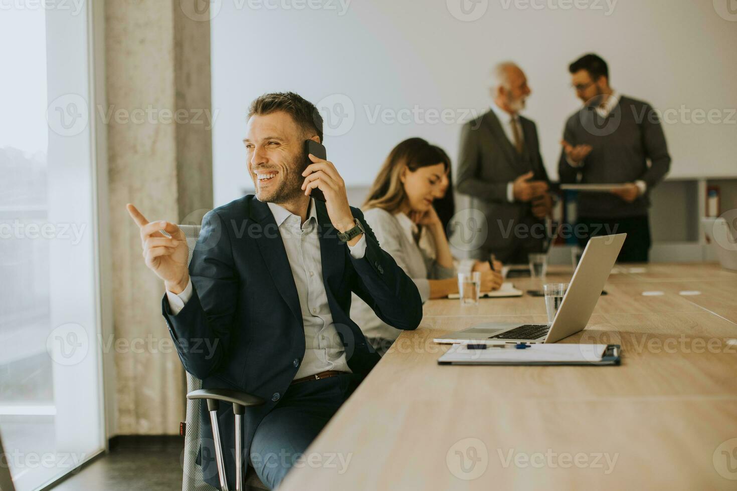 Junger Geschäftsmann mit Handy im Büro foto