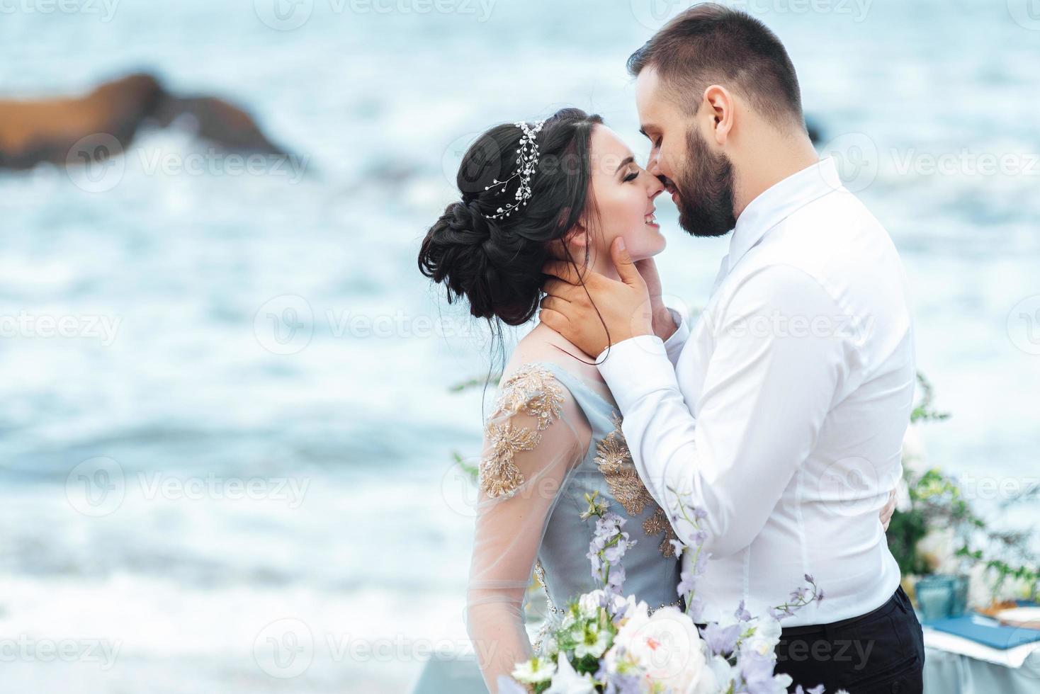 das gleiche Paar mit einer Braut in einem blauen Kleid zu Fuß foto