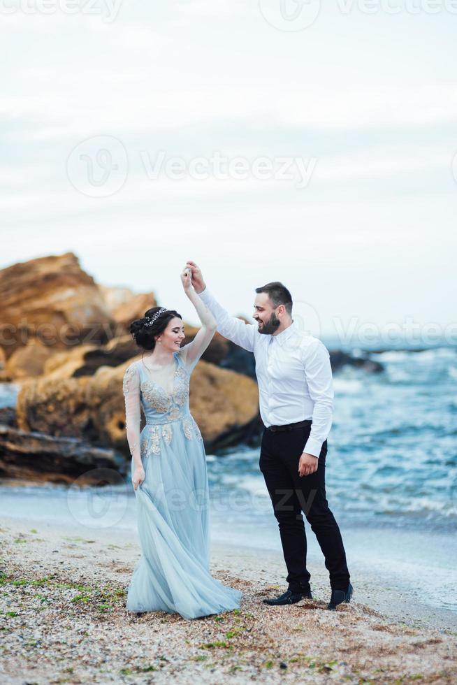 das gleiche Paar mit einer Braut in einem blauen Kleid zu Fuß foto