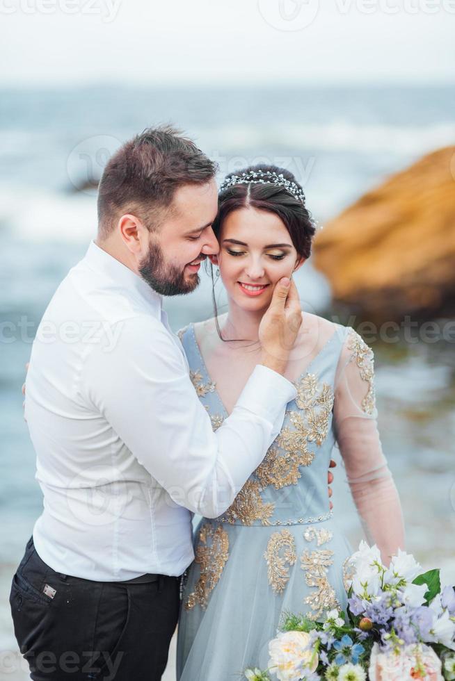 das gleiche Paar mit einer Braut in einem blauen Kleid zu Fuß foto