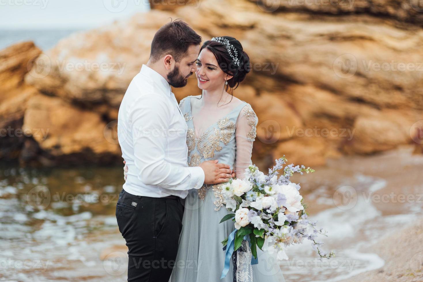 das gleiche Paar mit einer Braut in einem blauen Kleid zu Fuß foto