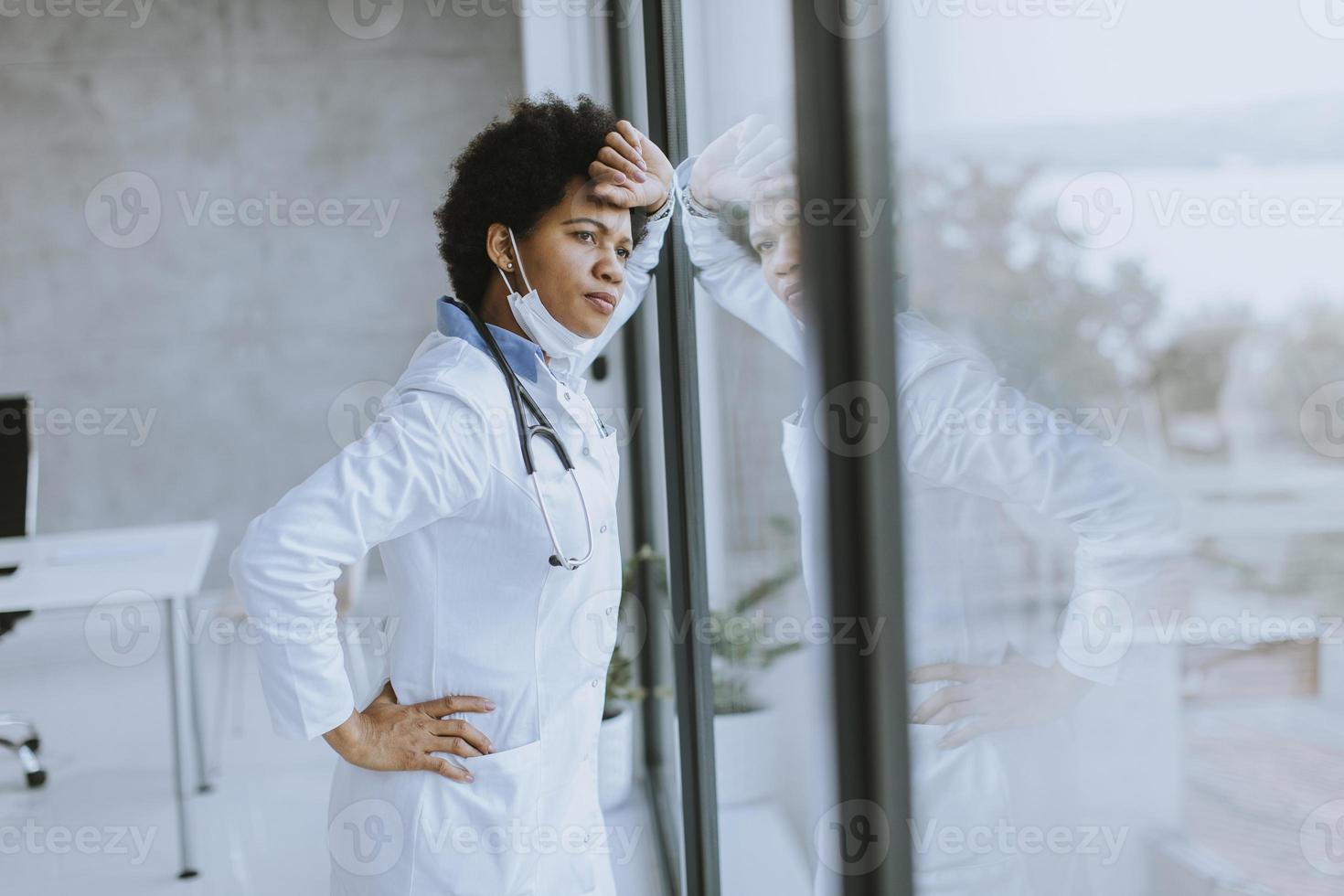 notleidender Arzt schaut aus dem Fenster foto