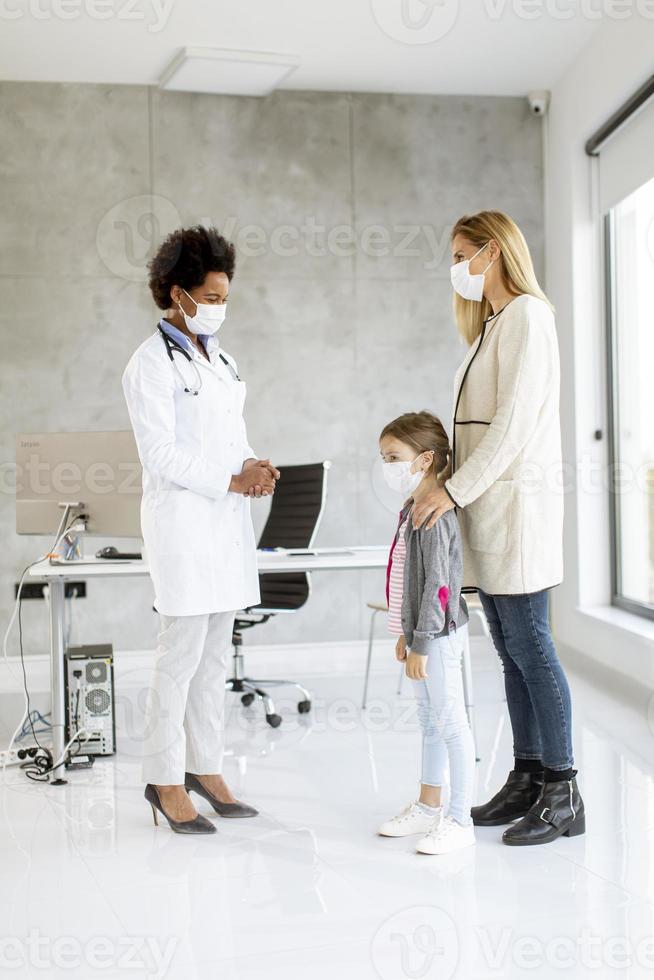 Kinderarzt untersucht kleines Mädchen foto