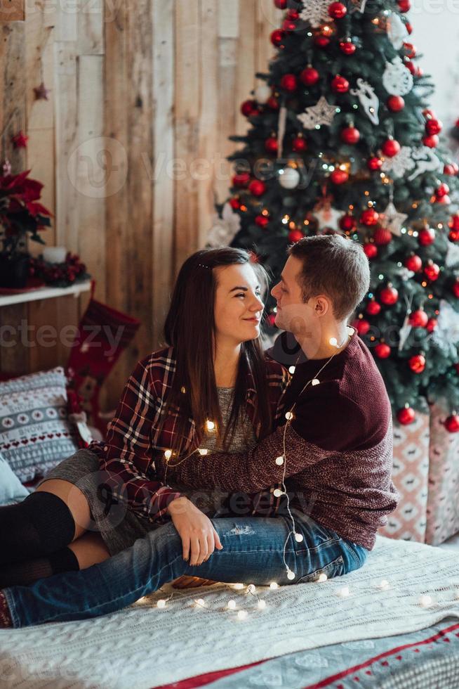 Mann und Mädchen feiern gemeinsam das neue Jahr und schenken sich gegenseitig Geschenke foto