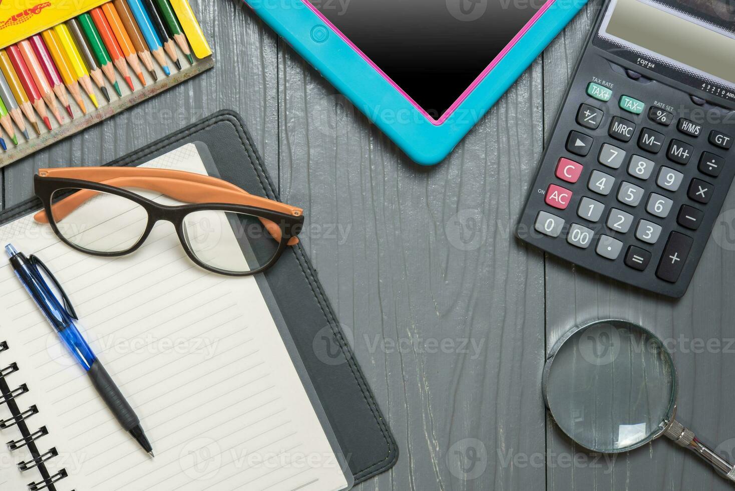 Notizbuch, Stift, Farbe Bleistift, Lupe Taschenrechner und Tablette PC, auf Holz Tabelle Hintergrund. Geschäft Konzept. foto