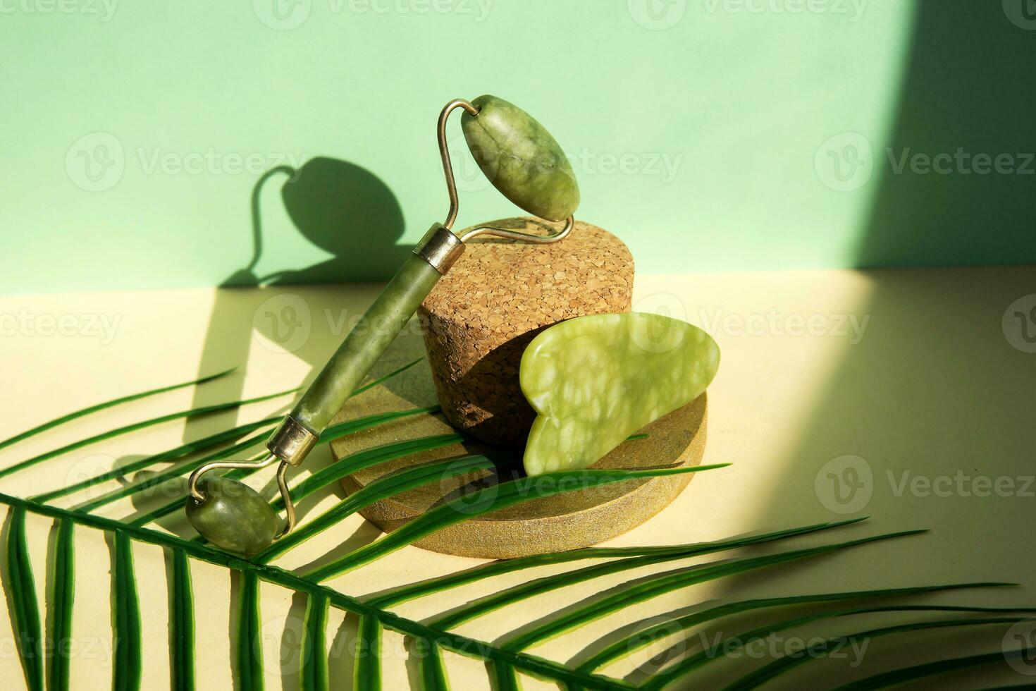 Jade gua sha Schaber und Gesichts- Massagegerät auf Beige Hintergrund. Heben und Tonen Behandlung beim heim. foto