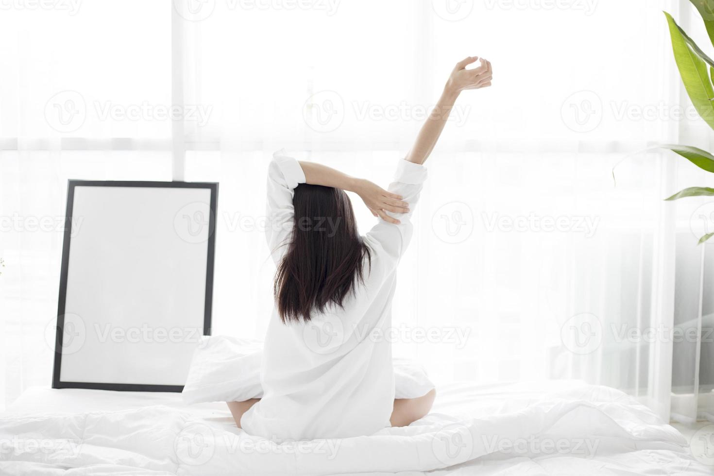 Frau streckt sich im Bett foto