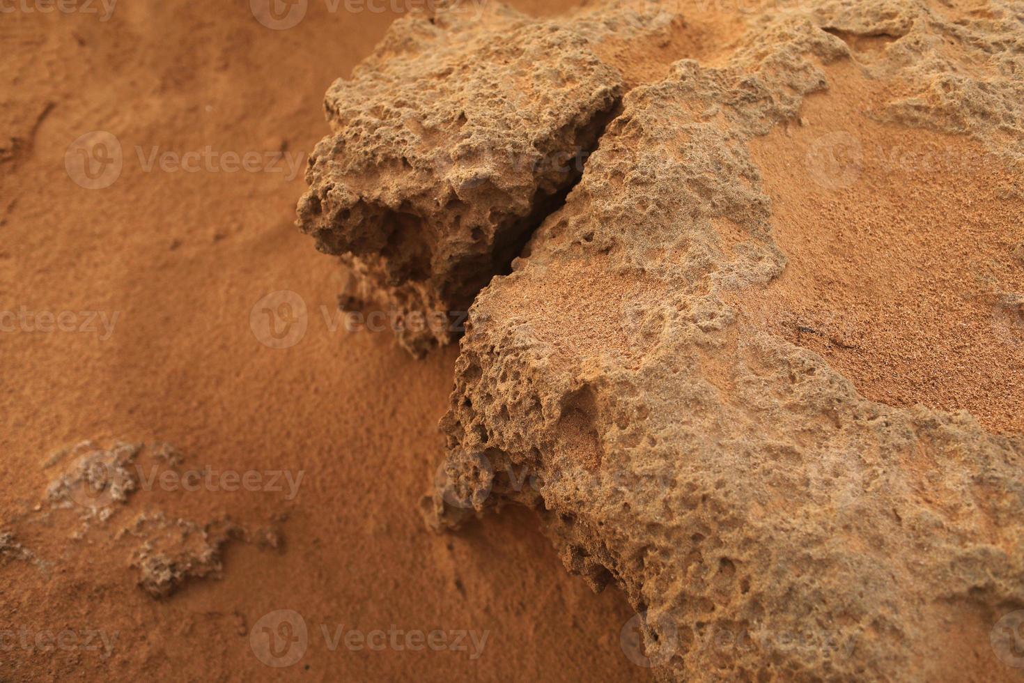 felsiges Ufer mit rotem Sand des Mittelmeers foto