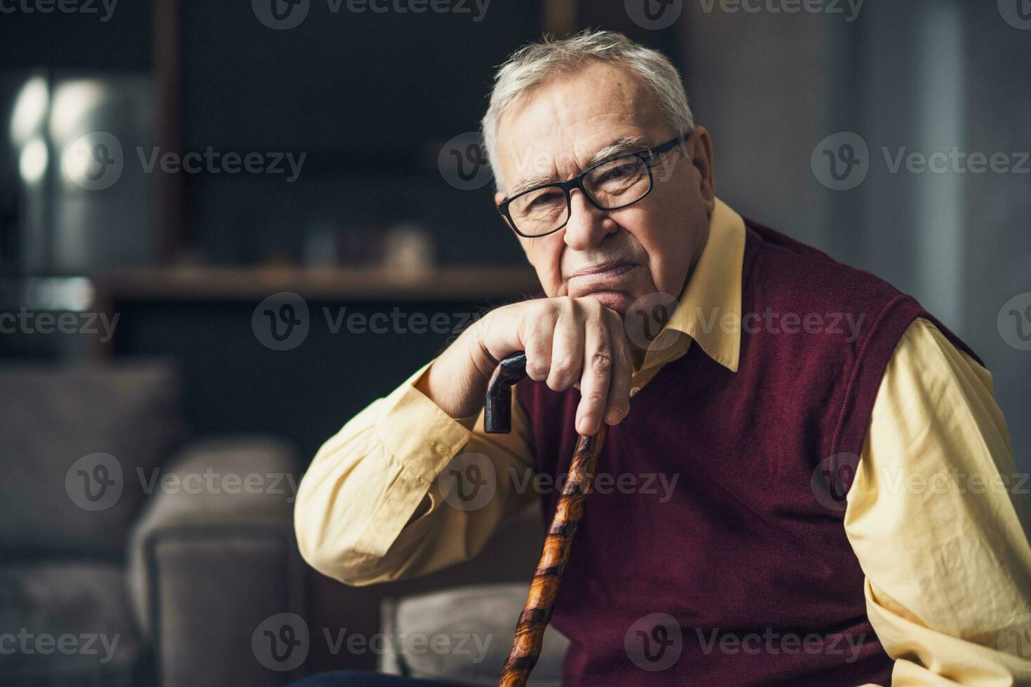 nachdenklich und besorgt Senior Mann ist Sitzung auf Bett im seine heim. Porträt von Senior Mann mit Gehen Stock. foto