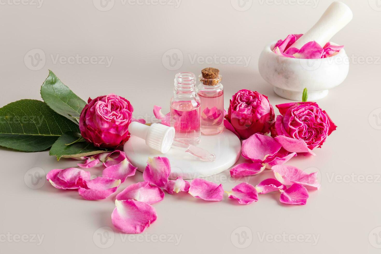 ein schön Komposition von kosmetisch Flaschen mit ein Gesichts- Haut Pflege Produkt gemacht von Rose Blütenblätter. Rosa Blumen und Blütenblätter. Granatwerfer mit Stößel. foto